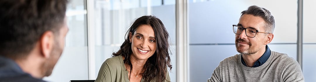 Twee mensen in gesprek aan tafel tijdens een adviesgesprek